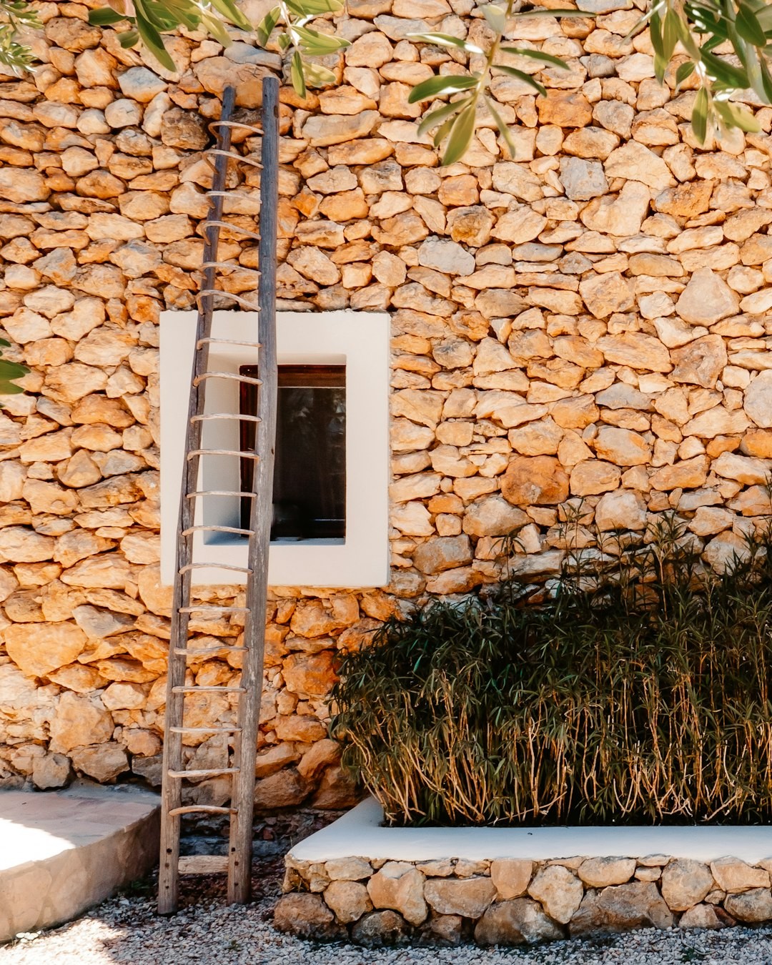 white wooden ladder leaning on brown brick wall in ibiza villa