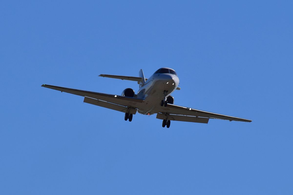 Private jet on blue sky background