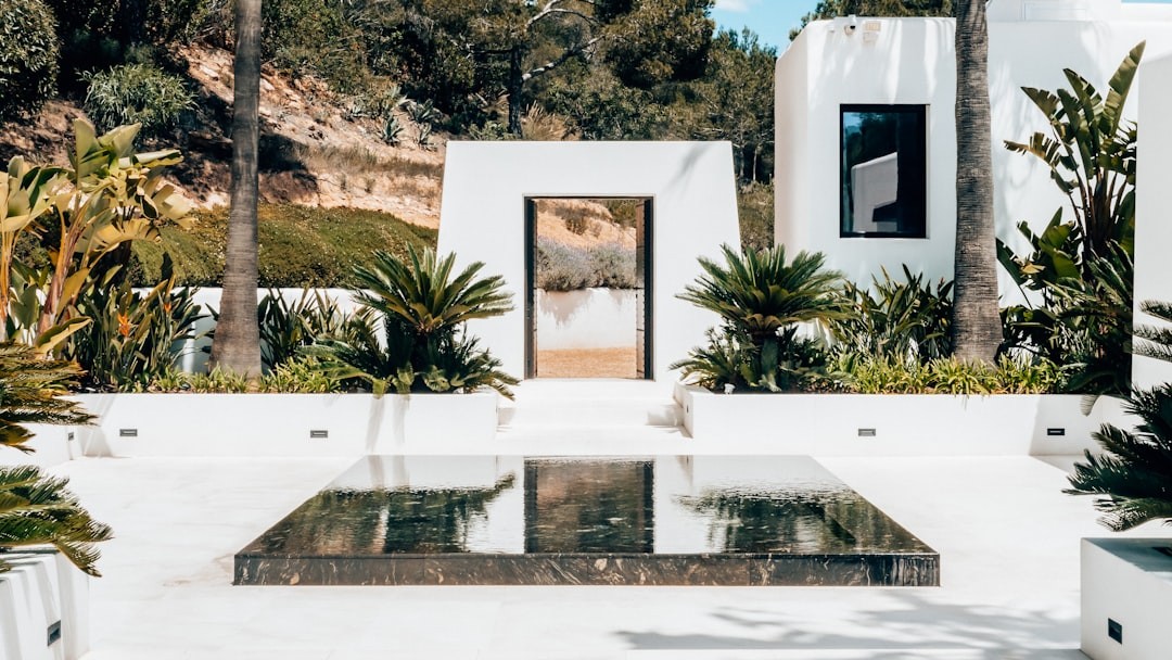 a white house in ibiza with a glass table in front of it